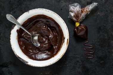 Chocolate ganache in the bowl and in the bag   clipart