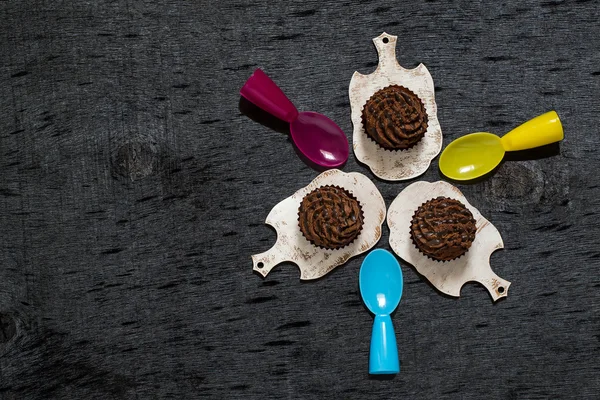 Mini bolos de chocolate e colheres de sobremesa coloridas — Fotografia de Stock