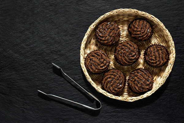 Chocolate mini cakes in a wicker basket — Stock Photo, Image
