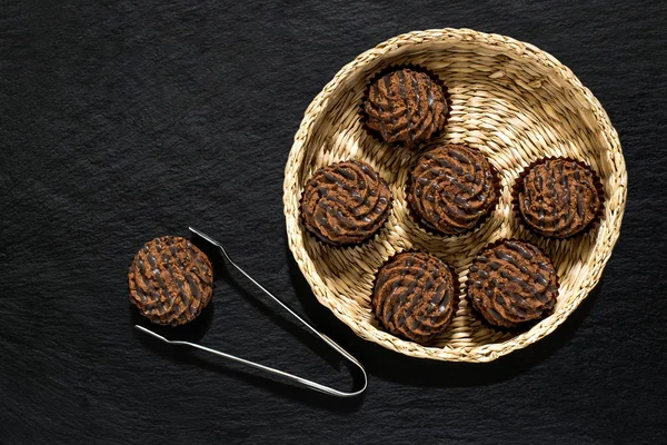 Mini bolos de chocolate em uma cesta de vime — Fotografia de Stock