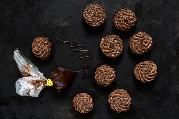 Chocolate mini cakes and homemade pastry bag — Stock Photo, Image