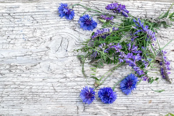 Kytice divokých květin na staré dřevěné pozadí — Stock fotografie