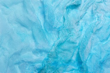 Buruşmuş açık mavi gazlı bezin parlak arkaplanı. Dekorasyon için tasarımda kullanılır
