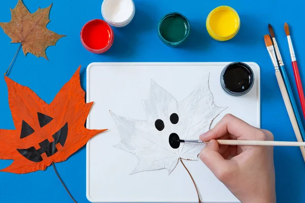 Drawing Halloween characters on dry autumn leaves. Children\'s art project. DIY concept. Decor for holiday party. Step 8. Draw ghost