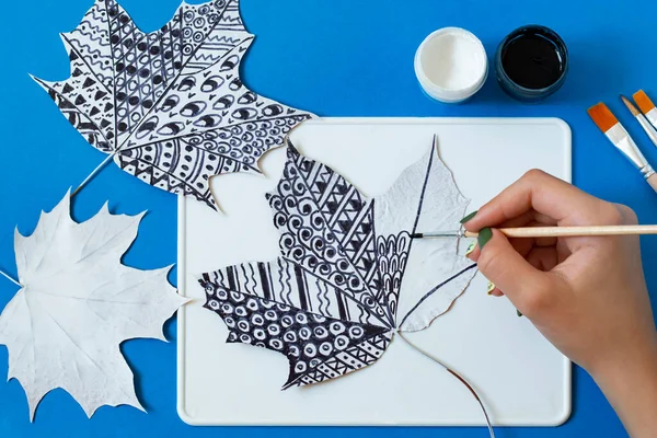 Hand-painted dry autumn maple leaves. Creative art project. Variant 11. Black doodles on white