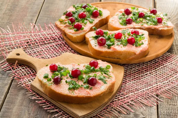 Bruschetta com manteiga de salmão, caviar capelim, cranberry e ela — Fotografia de Stock