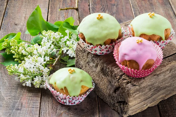 Cupcakes with colored glaze and white lilac — Stock Photo, Image