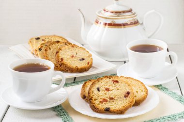 Cake with raisins, and two cups of tea 
