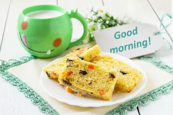 Cake with candied fruit, milk in a mug — Stock Fotó