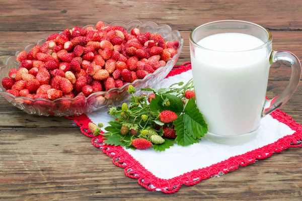 A healthy breakfast: a ripe wild strawberry and a mug of milk — Stock Photo, Image