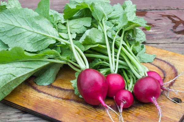 Fresh organic radishes on a chopping board — Stock Photo, Image