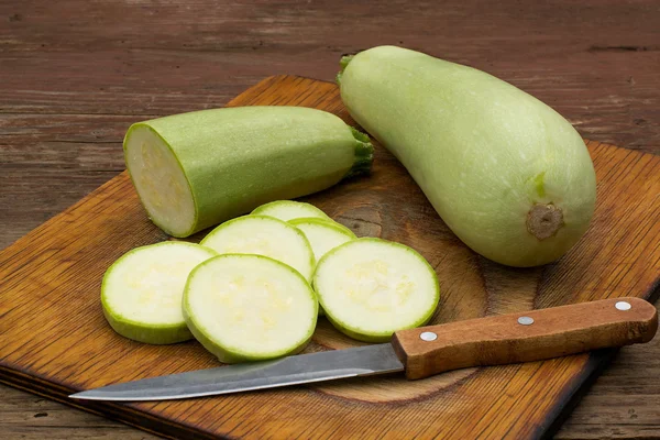 Calabacín y cuchillo en una tabla de cortar — Foto de Stock