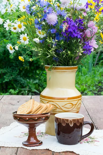 Té de hierbas, galletas y un ramo en un jarrón de cerámica — Foto de Stock