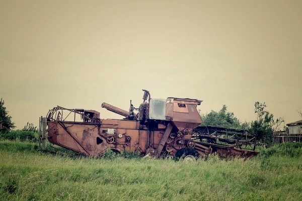 Velha colheitadeira abandonada na grama — Fotografia de Stock