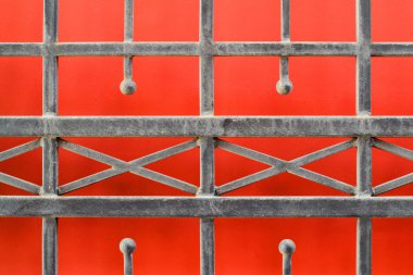 Metal grille on a red background 