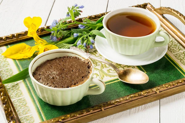 Breakfast on a tray: a chocolate cupcake and a cup of tea — ストック写真