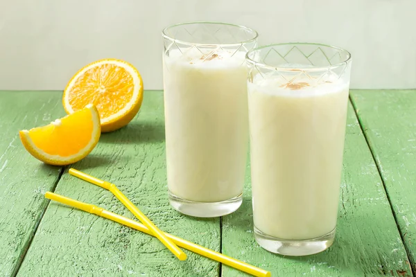 Коктейль из свежих органических ингредиентов: молоко, апельсиновый сок, орех — стоковое фото