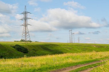 High-voltage line among meadows and fields 