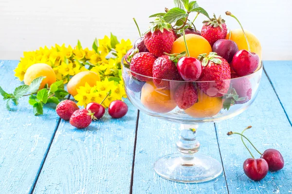 Ripe berries cherries, strawberries and apricots in a vintage va — Stock fotografie