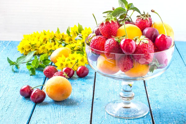 Lots of strawberries, cherries and apricots in a vintage glass v — Zdjęcie stockowe