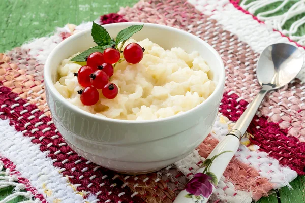 Rice pudding with red currants on a breakfast — Stockfoto