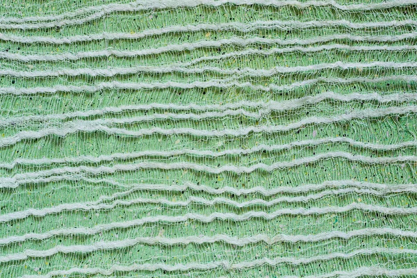Grüner Hintergrund mit dünner Gaze auf der Oberfläche — Stockfoto