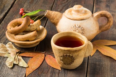 Rustic Tea Party: hot tea in pottery and autumn leaves 