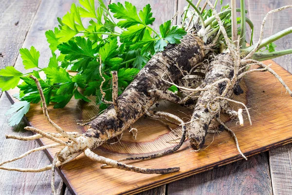 Fresh roots and parsley on a board — Stock Photo, Image