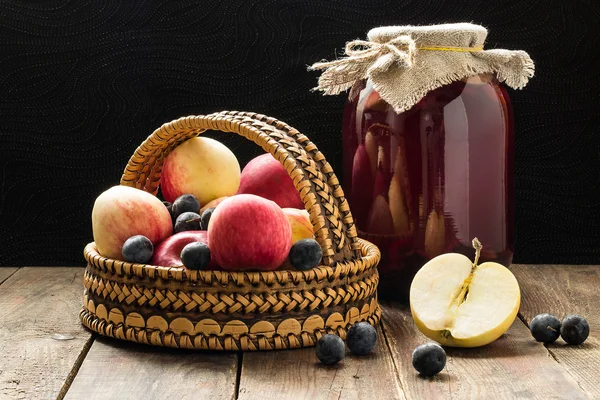 Manzanas y espino negro en una cesta y compota de frutas enlatadas de un —  Fotos de Stock