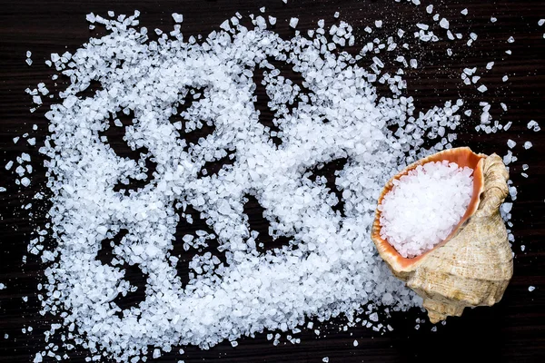 Scattered sea salt and seashell — Stock Photo, Image