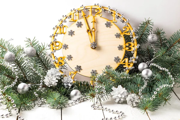 Decorative clock showing midnight in spruce branches — Stock Photo, Image