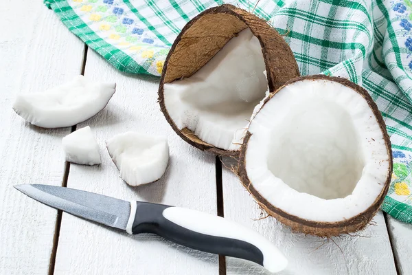 Poloviny kokos, nůž a kokosové dužiny — Stock fotografie