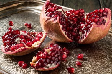 Pieces of a pomegranate with grains on a tray 