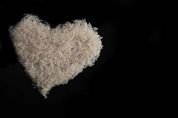 Riz blanc sur fond noir en forme de cœur avec un endroit pour l'inscription. Basmati — Photo