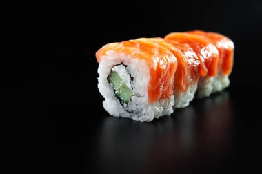 Siyah arka planda kırmızı balık sürüleri izole edildi. Siyah arka planda suşi..