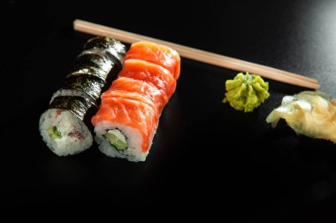 Wasabi ve Imube 'nin siyah arka planında suşi.