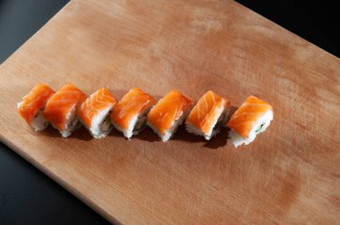 Tahtaya saplanmış bir bıçakla Philadelphia 'yı yuvarla. Eldivenli bir adam. Güvenli yemek.