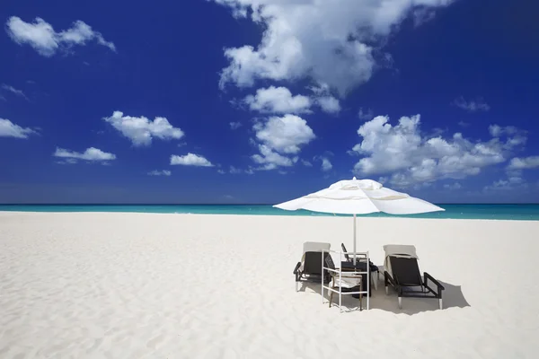 Parasol met ligstoelen op het tropische eiland — Stockfoto