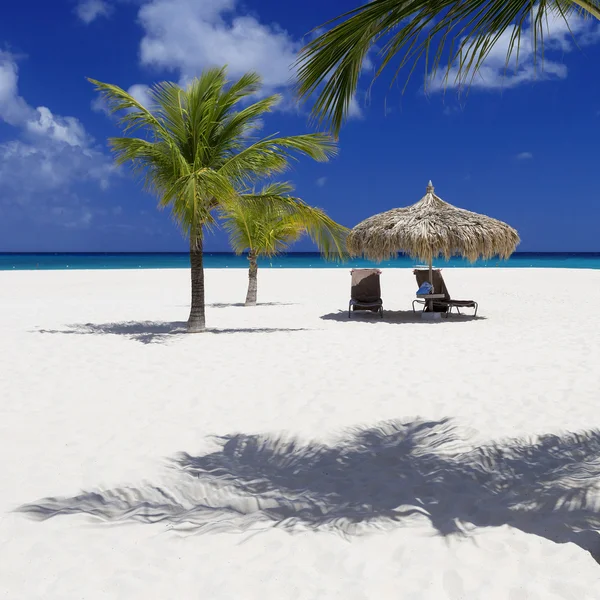 Parasol met ligstoelen op het tropische eiland — Stockfoto