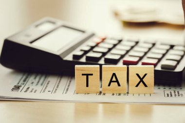 Vergi kavramı. Hesap makinesiyle kağıda konulan kelime vergisi, yıllık vergi ödemeleri için hesaplanmış bireysel gelir vergisi..