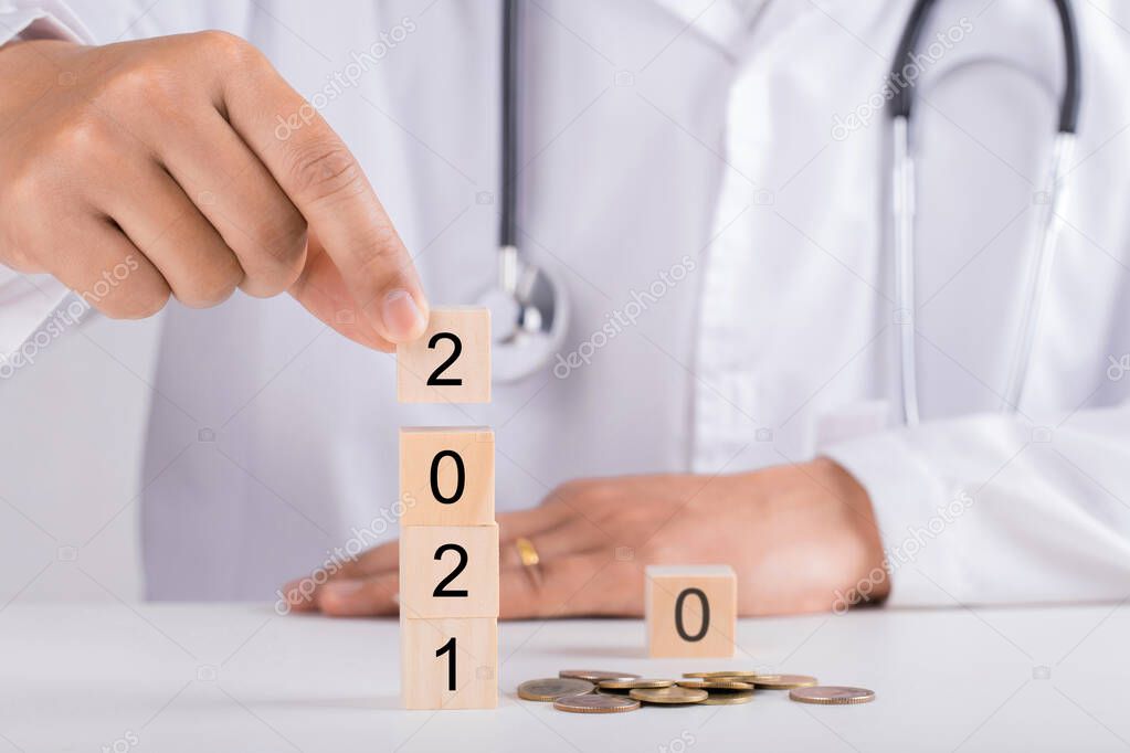 Doctor hand holding wooden blocks for 2021. New year and health concept.