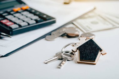 Emlakçı ve müşteriyle ev anahtarı. Konut kontratı için tartışıyorlar. Sigorta ya da kredi emlak danışmanı.