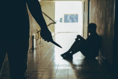 Şiddet yanlısı bir adam, odanın önünde genç bir adama saldırmak için bıçak taşıyor. Aile içi şiddet sorunları..