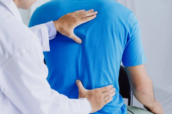 Male doctor therapist doing healing treatment on man's back.Back pain patient, treatment, medical doctor,massage for back pain relief office syndrome