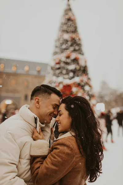 Genç ve güzel bir çift öpüşüyor ve gülüyor. İnanılmaz bir kış tatili. Sevgililer Günü.