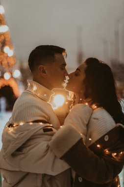 Noel 'den önce, kışın açık havada aşık olan genç bir çift. Sevgililer Günü 'nde iki sevgili sarılıp öpüşüyor..