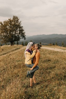 Birbirine aşık çiftler dağlarda yürüyüp eğleniyorlar.