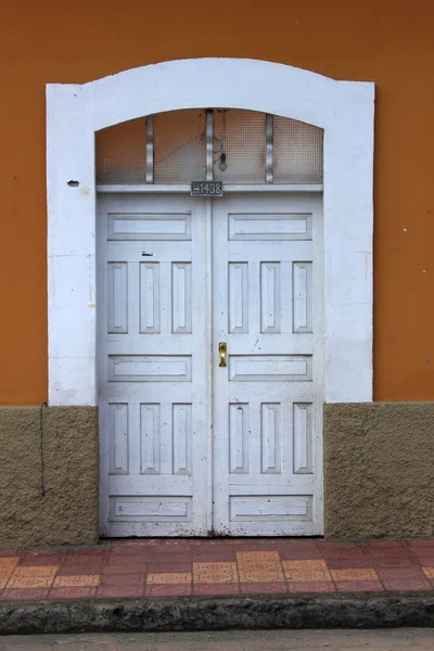 Witte deur in een bruine muur — Stockfoto