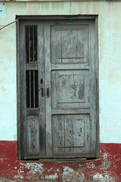 Verweerde grijs deur in een muur — Stockfoto