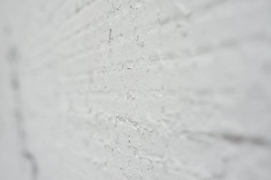 Üzerinde çatlaklar ve çizikler olan beyaz karolar olan eski bir duvar.